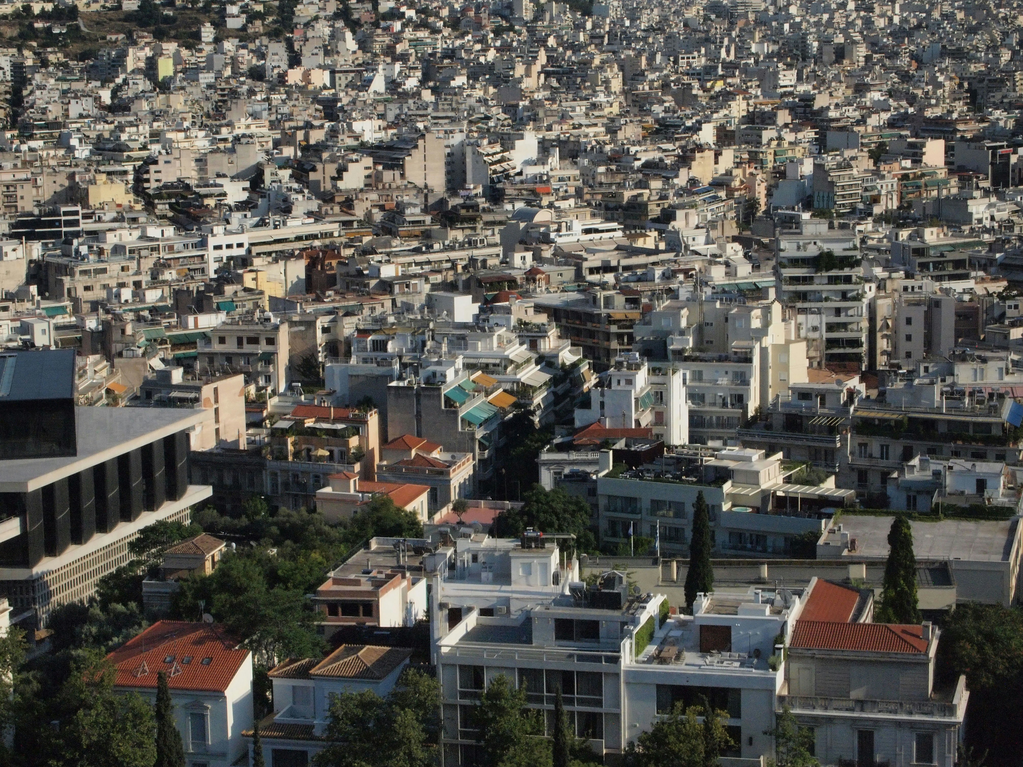 Greece housing affordability crisis showing residential apartment buildings in Athens with for rent signs representing rental market pressures